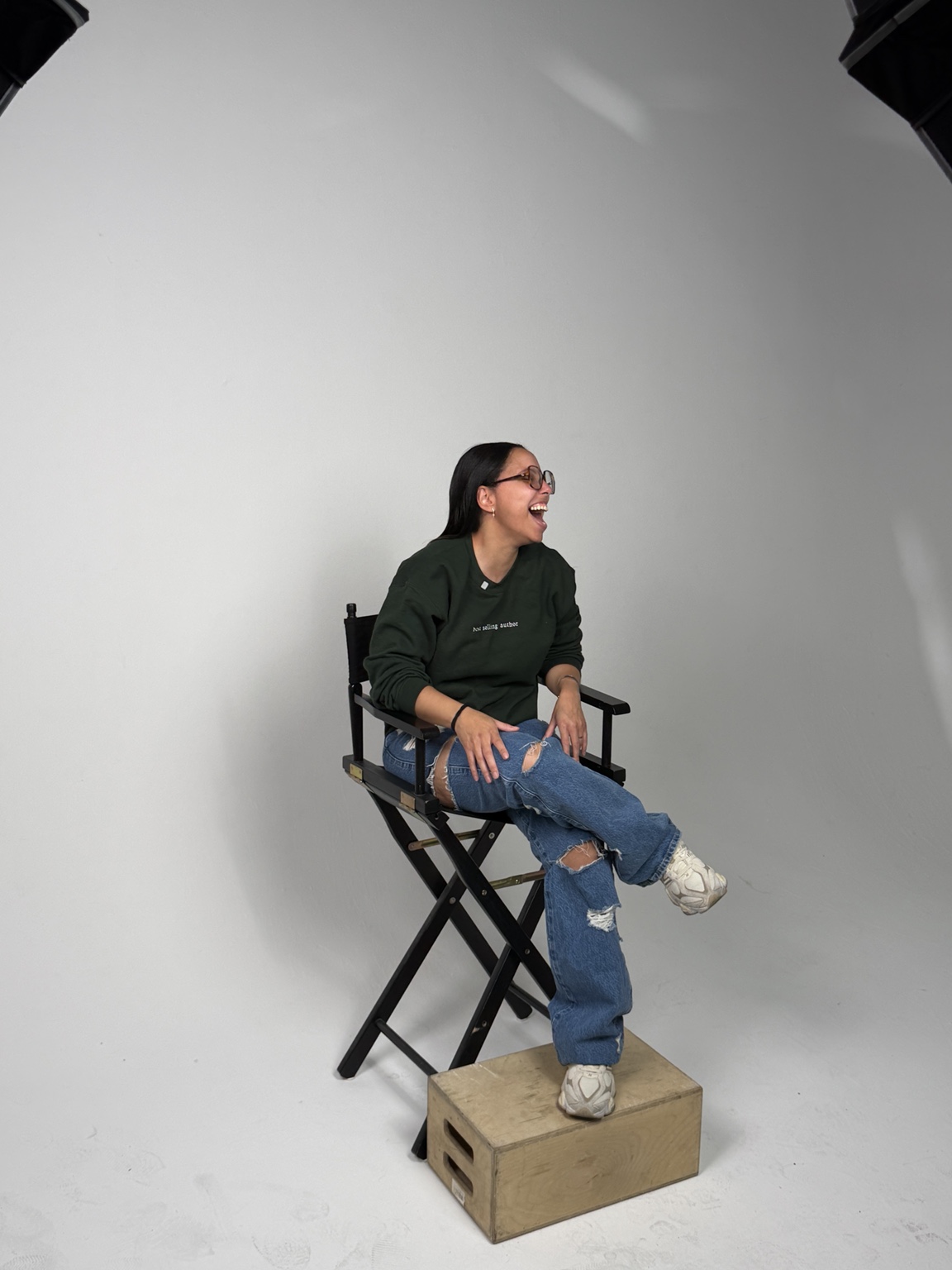 Nicole Strother, founder of I AM A MOTHER, laughing in a studio chair