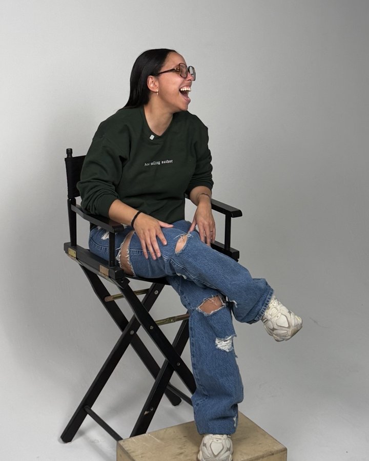 Nicole Strother, founder of I AM A MOTHER, laughing in a director's chair